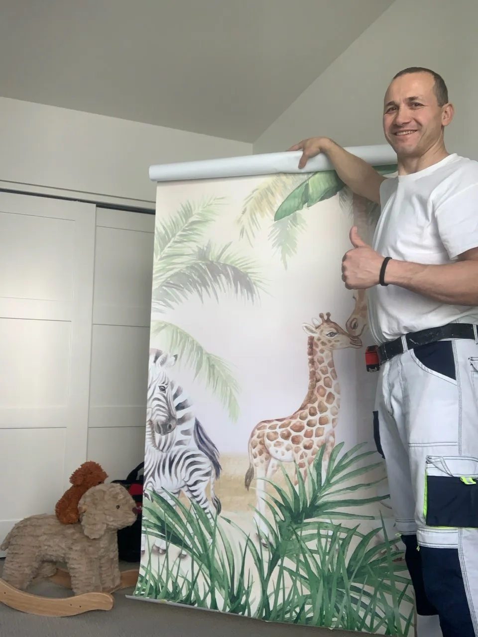 Lead wallpaper installer fitting a tropical-leaf pattern on a high-ceiling Las Vegas lobby wall
