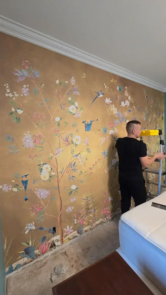 Wallpaper craftsman aligning a chinoiserie mural panel in a Las Vegas bedroom